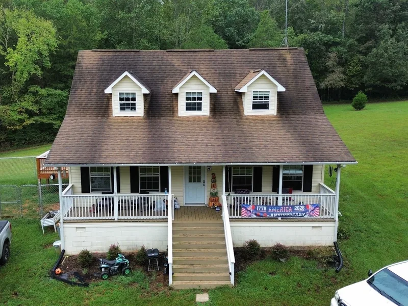 Home with three dormers before, with a worn and stained brown shingle roof