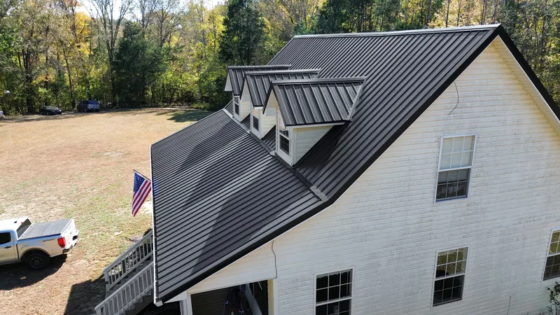 The gable end, with every dormer wrapped in matching black metal