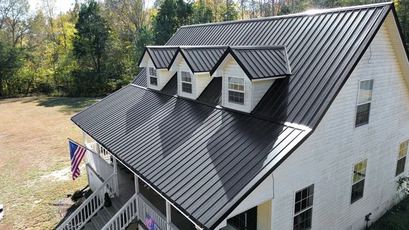 Afternoon sun across the new black Ag panel roof and dormers